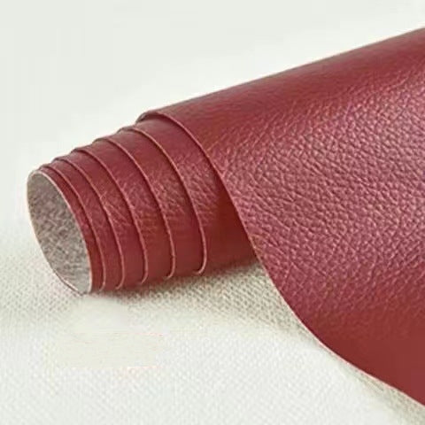 Roll of red leather-like material on a white background