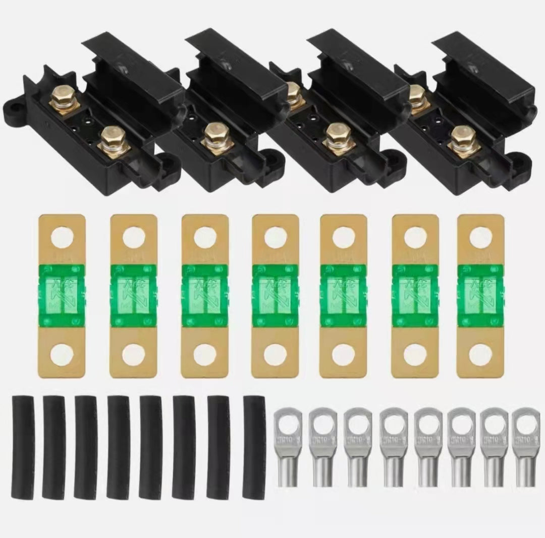 Set of midi fuse  kit connectors including black terminal blocks, green and gold splices, and black and silver wire ends on a white background.