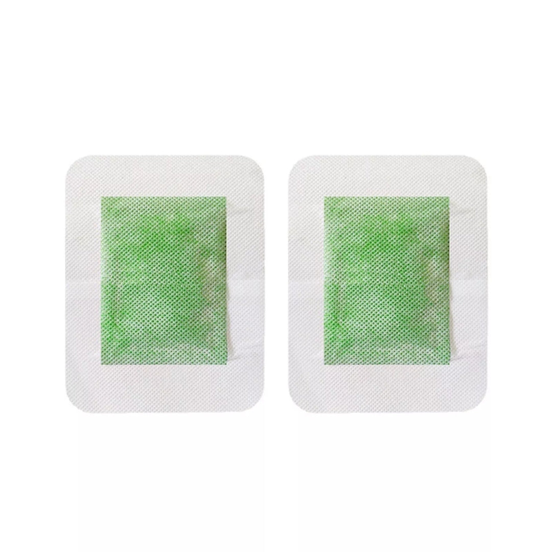 Two detox foot patches with a green gel center on a white background