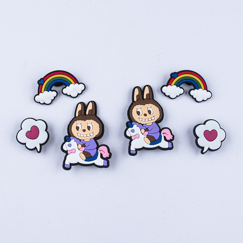 Two labubu shoe charms pins featuring a character riding a unicorn with rainbows and clouds in the background.