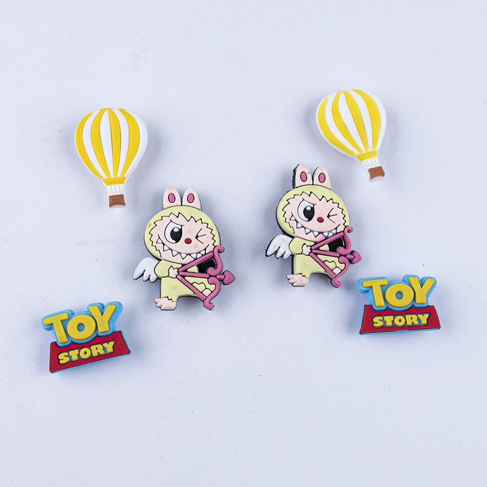 Two labubu shoe charms pins with hot air balloons and 'Toy Story' branding on a light purple background.
