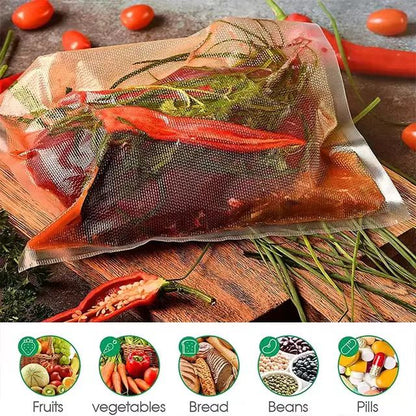 Vacuum-sealed bags of food on a wooden surface with vegetables and herbs.