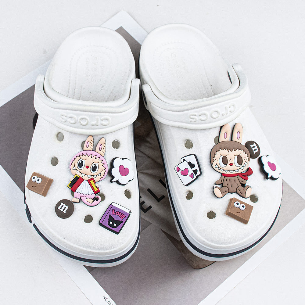 White clogs with cartoon character labubu shoe charms decorations on a white background