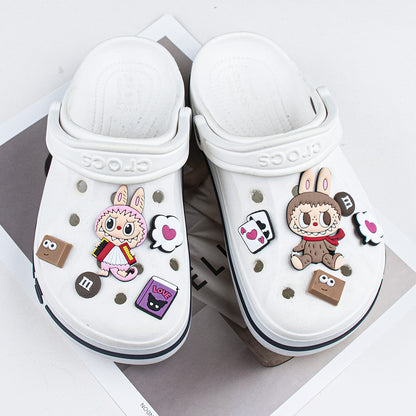 White clogs with cartoon character labubu shoe charms decorations on a white background