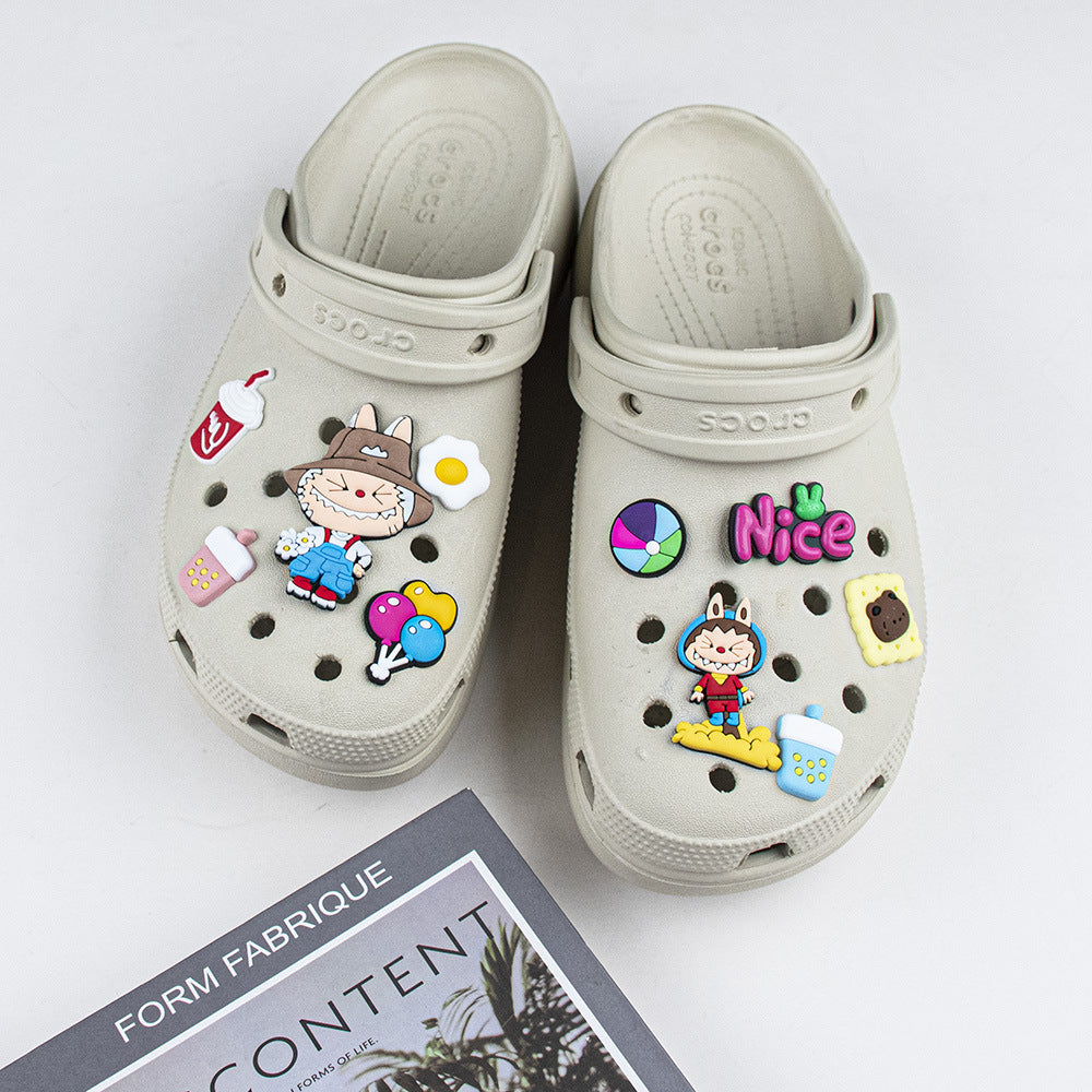 Beige clogs with colorful decorative labubu sheoe charms on a white background