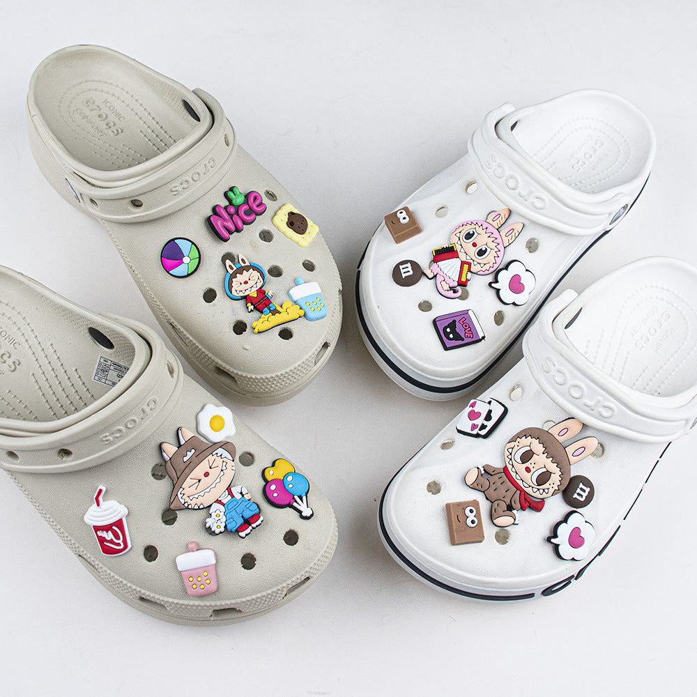 Two pairs of clogs with colorful decorative pins on a white background
