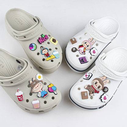 Two pairs of clogs with colorful decorative pins on a white background